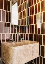 Honed stone finishes—including Jade Quartzite, Quartzite Nero, Calacatta Viola, and Red Travertine—add colorful moments throughout the home.