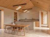 The kitchen at Taigh Créadha was created as a social space by 56 North Kitchens, who also made the doors, dining table, and bookshelves, all in oak veneer. Vintage Ercol stacking chairs are complemented by a pair sourced secondhand.