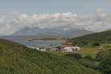 Taigh Créadha has stunning views northwest across Loch a' Ghlinne to the Cuillin mountain range. To the left of the home, Neil and Laura Stephens’ horse, Dram, can be seen outside its shelter and stable, alongside the couple’s Hebridean sheep. The Dualchas architects’ house is clad in Siberian larch, with an aluminum-clad guest studio to its right.
