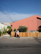 Knight laid out the landscape plantings around the duplex, which he delineated with Hardie board and wood siding, both painted in Benjamin Moore’s Burnt Sienna. He also built the low front fence out of rough-sawn cedar.