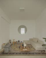 In the living room, a modular sofa from Helmut joins a Tori stool made of sand-cast aluminum and an Orno wood chair, both by Ries.