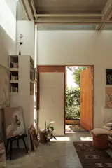 An open-layout ground floor holds a living area, a sleeping area, and a kitchenette.