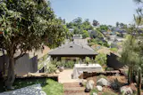 The terraced backyard flows down to the home’s rear facade.