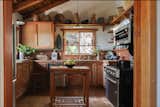 The Douglas fir cabinetry in the kitchen in the main house is original, built in 1982. So is the tile backsplash, the faucet, and the range. The island, a vintage oak table, was sourced from Facebook Marketplace by co-owner and designer CeCe Gehrig.