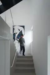 Félix, the couple’s son, coming down the cement stairs of the new family home.