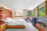 The home has three levels, and the primary suite takes up the entirety of the top floor. It includes a private bathroom and a balcony.