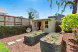 The backyard has irrigated, raised planter beds and a detached studio.