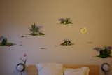 Brooklyn artist Laura Chautin’s whimsical mural vignettes help frame her bed.
