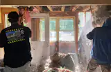 A team rips out its molding insulation in preparation for a retrofit with hemp.