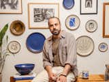 The Eastern Fork Coforder Alek Matisse poses with Matisse by collection of ceramics.