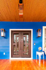 The home’s copper roof and exterior accents complement the spiral slide. The custom gas lanterns on the porch are from Bevolo in New Orleans.
