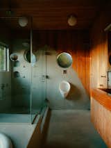 The bathroom, finished in cement and cedar paneling, includes a urinal—a special request of David’s that Stephanie and Pete chose to keep.
