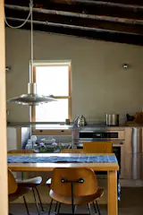 The straightfoward kitchen has a custom stainless-steel countertop and storage unit.