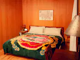 For an upstairs bedroom, John made side tables out of plywood left over from the house construction. The desk is his father’s childhood desk, and the Virgen de Guadalupe blanket is from a market in Juárez, Mexico, not far from where Sylvia grew up.