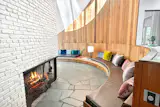 Custom millwork forms a curvaceous built-in seating area near a fireplace.