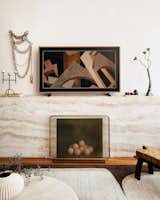 The false fireplace in Adam’s living room was constructed by carpenter Trevor Miles, then wrapped in travertine-style wallpaper from Belarte.