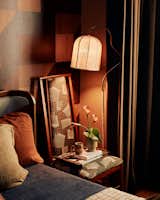 To add warmth and coziness to the bedroom, Rodriguez hung wood-look wallpaper from Belarte, then paired it with a bed from Soho Home, a floor lamp from Crate & Barrel, and vintage chairs.