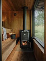 A woodburning Narvi stove heats the room, which has two tiers of seating and large window.