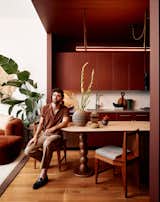Adam Levy sits in the kitchen of his rented midtown apartment. Rodriguez furnished the apartment with a mixture of vintage pieces, like Adam’s dining chairs, with newer pieces, like the plant stand from West Elm.