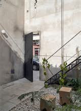 The new residence has a courtyard at the entry, where an iron stair leads to a terrace.