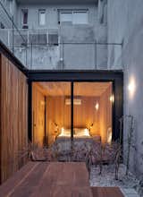A bedroom with floor-to-ceiling windows is part of the prefabricated portion of the home.
