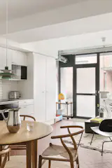 An Indian steel pitcher from HAY and Raami tumbler from Iittala sit on the dining table.