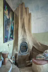 A woodburning fireplace with a sculptural, tree-shaped surround warms the den.