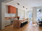 On first impression, the gray kitchen cabinets might seem typical but what elevates them is the terra-cotta Breccia Pernice marble countertop and backsplash they anchor, not to mention the monomaterial island. "If you took that same kitchen and replaced the marble with a solid colored quartz you’d have an entirely different looking kitchen that would have significantly less visual impact," Lyons says.