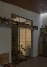 A built-in bookshelf spans an opening between the living spaces and bedroom.