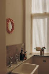 In the bathroom, various offcuts of stone form a backsplash and vanity. Juli made the toilet paper holder out of materials found in her studio. The sink came from a boys’ school and was sourced from an architectural salvage in England.