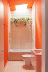 The rental’s bathroom is finished in Benjamin Moore’s Hot Spice, paired with color-matched grout.