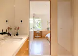 The primary bathroom echoes the rest of the home’s materials and neutral tones. The cabinetry pulls are travertine.