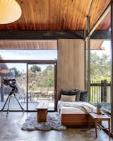 Tall windows and sliding glass doors connect the upstairs living area to the outdoors.