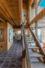 The home’s preserved staircase ascends alongside a double-height wall of windows to the second story.