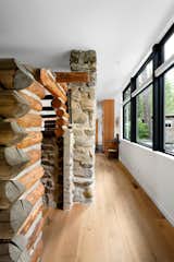 The cabin, with its hand-hewn logs and storybook stone chimney, was preserved in place. Only a few roof logs were removed to make way for pendant lights. They were repurposed as the home’s front door and built-ins.