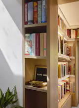 Lighting recessed into the underside of shelving gives the nook a warm glow.