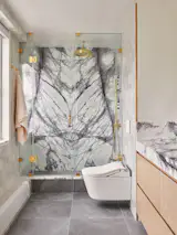 For the renovated primary bathroom, Jahanshahi sourced stone that he likens to an “abstract expressionist piece.”