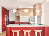 The kitchen features a Zia tile backsplash, as well as cabinetry and fluted millwork (in Benjamin Moore’s Burgundy) that were designed by Opa Architecture and fabricated in-house by De Lux Construction.