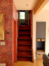 Wooden ladderlike stairs that are original to the home lead to an alcove where one can snuggle up and watch TV.