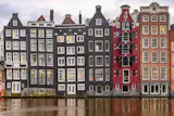 General view of Amsterdam's city center with the canals, boats, famous for their architectural style reclining houses, the surrounding buildings, the central train station Amsterdam Centraal, the Damrak avenue and canal, the Basilica of Saint Nicholas, tourists and bicycles. The 17th-century canal ring area, known as Venice of the North is a UNESCO World Heritage Site in the Dutch capital. Amsterdam, Netherlands on January 13, 2024.