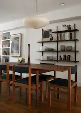 Secondhand furniture helped bring together the home on a tight budget. Jeff found a set of eight Danish teak dining chairs for around $400, and he refurbished them one by one. “They came with this beige fabric, but I know Kim would much prefer color so we bought a deep indigo fabric and I reupholstered them myself,” he says.