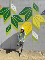 Artist Sandra Fettingis installing a mural at Sprouts Market in Aurora, Colorado.