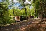 The home’s stained pine exterior blends in with the tree trunks, while its inner liner gives a sense of the warmth that awaits within. The couple found a piece of lichen on-site and had the home’s columns color matched to it.
