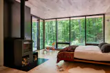 The primary bedroom has a woodburning stove, an en suite bathroom, and a private terrace with an outdoor shower.
