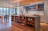 The kitchen’s open shelves—made of stainless steel and maple—are both practical and picturesque. The integrated appliances are by Fisher & Paykel.