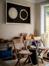 A mixture of new and vintage furnishings outfits the annex. Hyllis shelves from Ikea were cut and aged outdoors, the black stool is by Max Lamb for Hem, and the aluminum coffee table is Muji. The artwork is an 1851 daguerreotype of a solar eclipse, taken by Johann Julius Friedrich Berkowski.