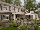 At the rear of the Sands Point, New York, home, a new window-wrapped conservatory space, topped with ornate cupola, becomes the sun-drenched breakfast room. Where the home was expanded, the white-painted AZEK trim is indistinguishable from the wood trim of the original structure.