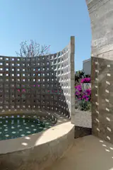 An outdoor spa screened by breeze blocks extends off the bathroom in the primary suite.