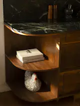The walnut millwork beneath the kitchen counter incorporates closed and open storage.