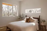 In the primary bedroom, a long, narrow window above the bed frames the landscape like an everchanging work of art. 